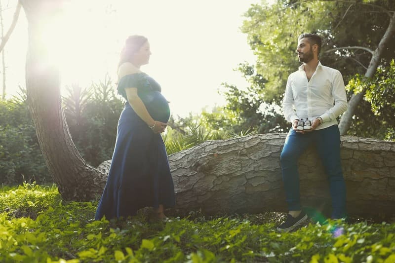 Foto coppia con donna incinta al bosco