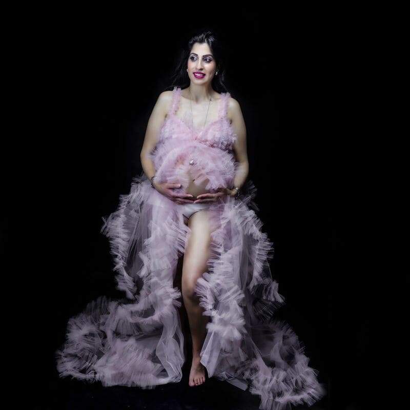 donna in gravidanza con vestito a piume